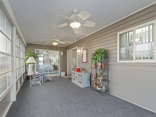 unfurnished sunroom with ceiling fan