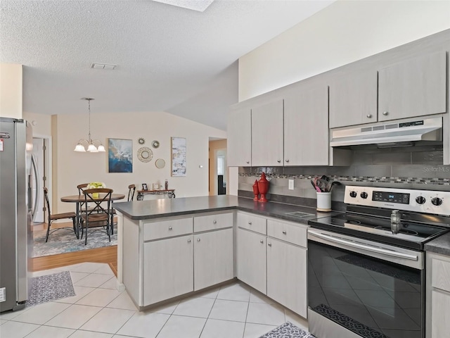 kitchen featuring lofted ceiling, light tile patterned floors, hanging light fixtures, stainless steel appliances, and kitchen peninsula