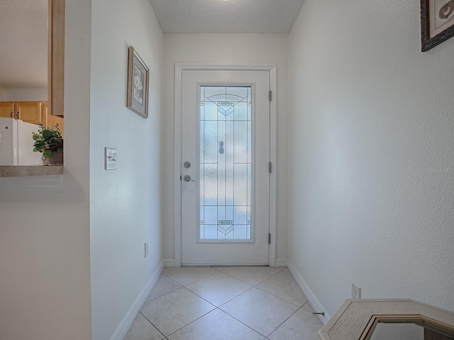 entryway with light tile patterned flooring and a textured ceiling