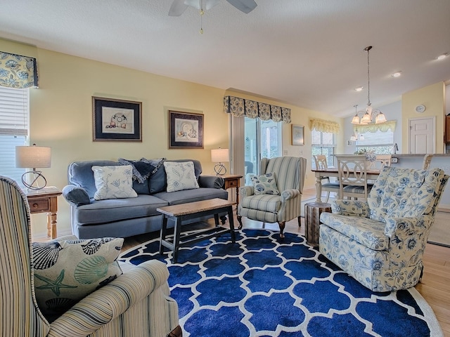 living room featuring lofted ceiling, hardwood / wood-style floors, and ceiling fan