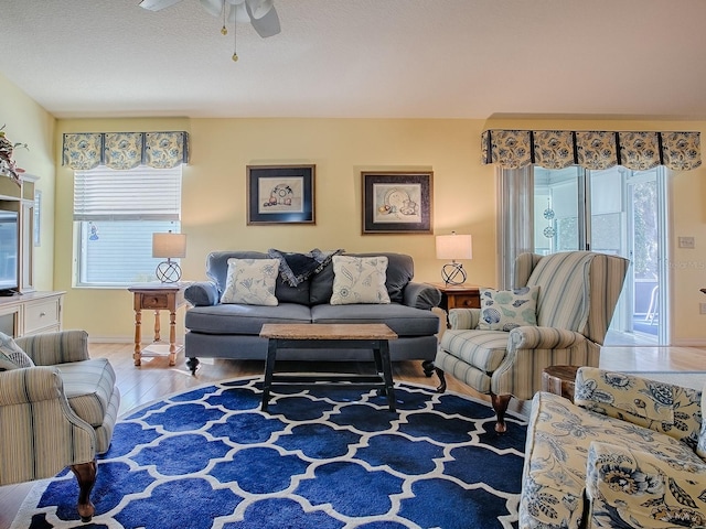 living room featuring wood-type flooring and ceiling fan