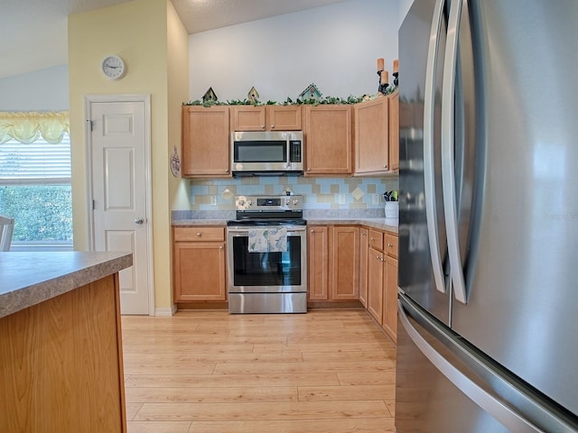 kitchen with decorative backsplash, light hardwood / wood-style flooring, and appliances with stainless steel finishes