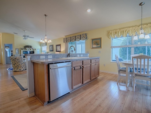 kitchen featuring decorative light fixtures, dishwasher, sink, a center island with sink, and light wood-type flooring