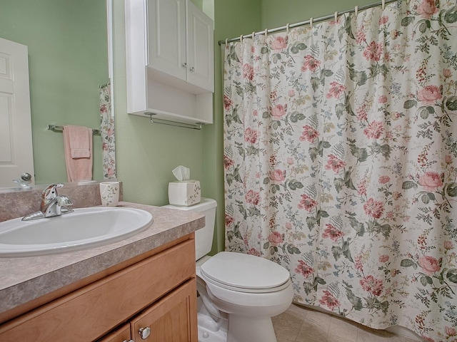 bathroom featuring vanity, tile patterned floors, and toilet