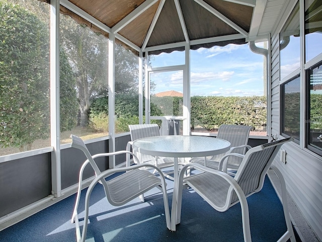 sunroom / solarium featuring vaulted ceiling