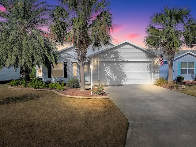 view of front of home with a garage and a lawn