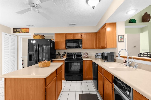 kitchen featuring sink, a textured ceiling, light tile patterned floors, a kitchen island, and black appliances