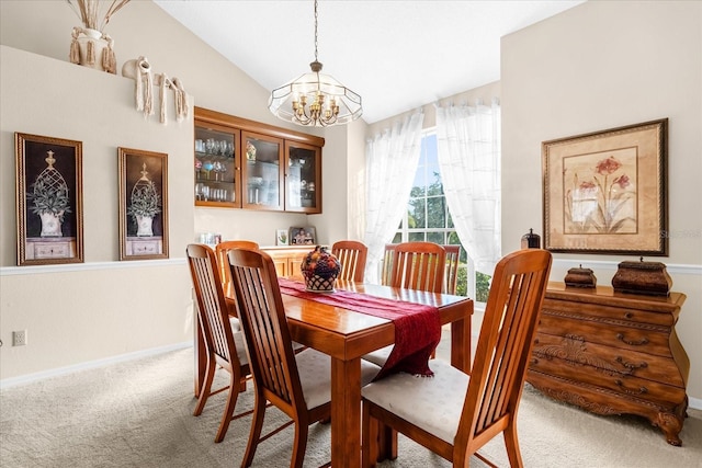 carpeted dining room featuring lofted ceiling and a chandelier