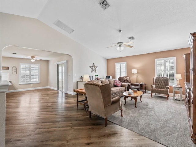 living room with dark wood-type flooring, ceiling fan, and lofted ceiling