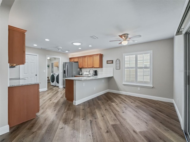 kitchen with sink, washing machine and clothes dryer, ceiling fan, and kitchen peninsula