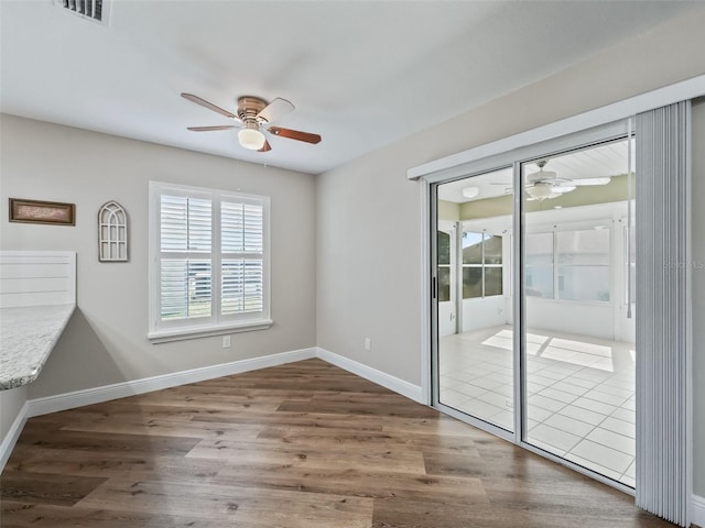 unfurnished room featuring ceiling fan and dark hardwood / wood-style floors