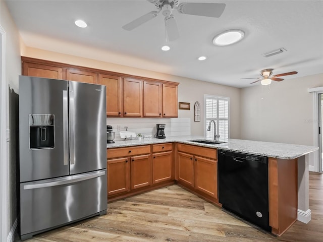 kitchen featuring sink, stainless steel fridge, dishwasher, light hardwood / wood-style floors, and kitchen peninsula