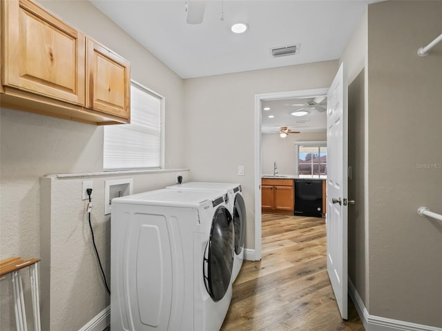 washroom with sink, light hardwood / wood-style flooring, ceiling fan, cabinets, and washer and dryer