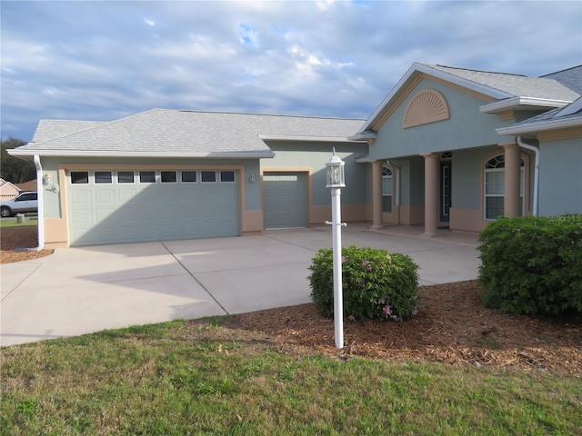 single story home with stucco siding, concrete driveway, a garage, and roof with shingles