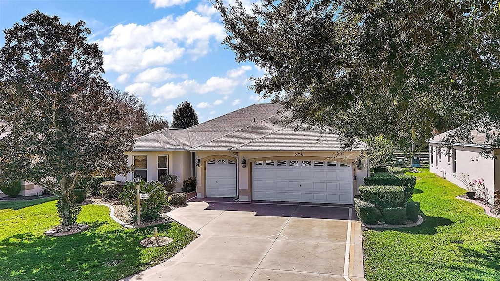 ranch-style house featuring a garage and a front lawn