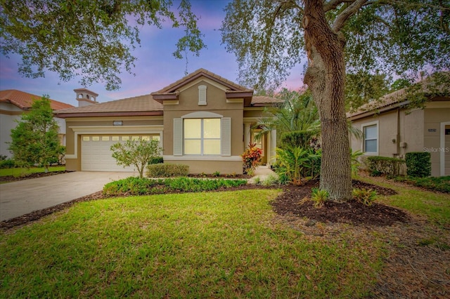 view of front of house featuring a garage and a lawn