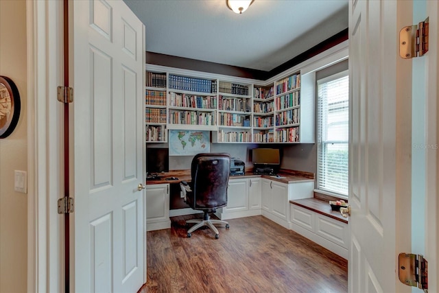 office area featuring wood-type flooring, a healthy amount of sunlight, and built in desk