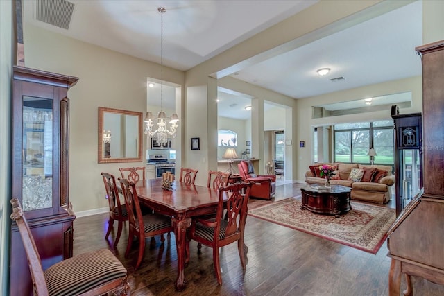 dining space featuring dark wood-type flooring and a notable chandelier