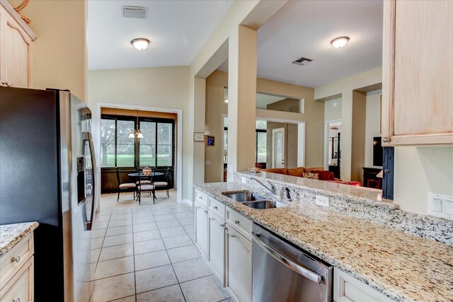 kitchen featuring light brown cabinetry, sink, light tile patterned floors, and stainless steel appliances