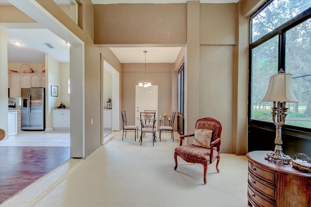 living area featuring a chandelier and a high ceiling