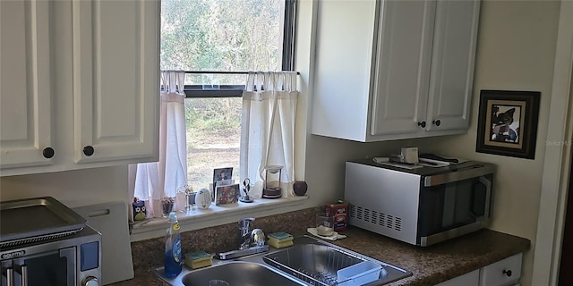 kitchen featuring white cabinetry and sink