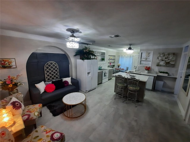 living room with built in features and ceiling fan