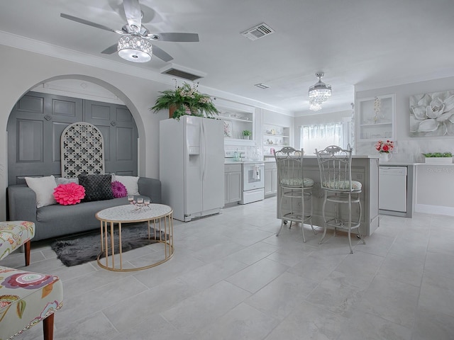 interior space featuring built in shelves, ornamental molding, and ceiling fan