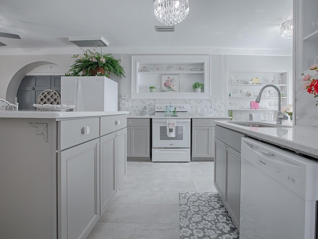 kitchen with sink, white appliances, crown molding, gray cabinetry, and an inviting chandelier