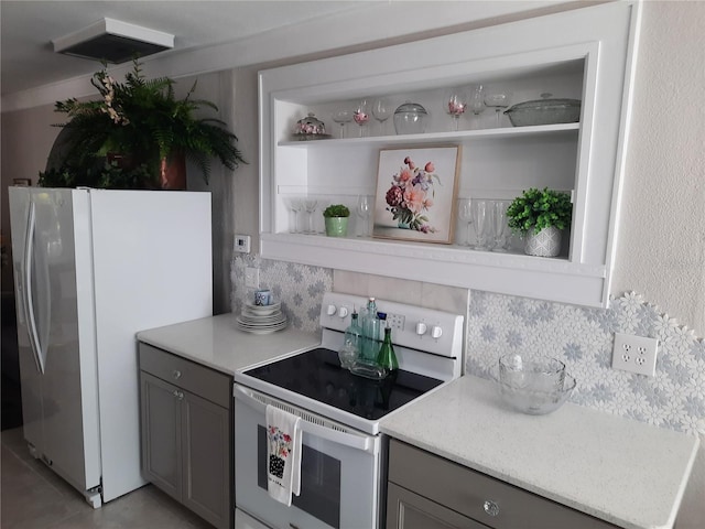 kitchen featuring gray cabinetry, white appliances, and decorative backsplash
