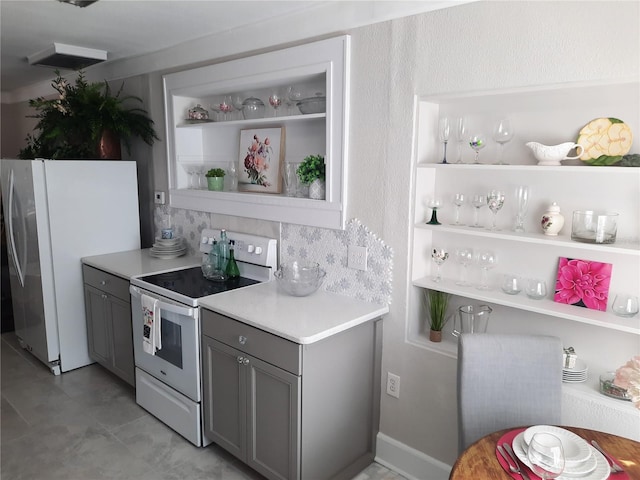 kitchen with fridge, gray cabinetry, built in features, and white range with electric stovetop
