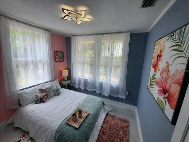 bedroom featuring multiple windows and ornamental molding