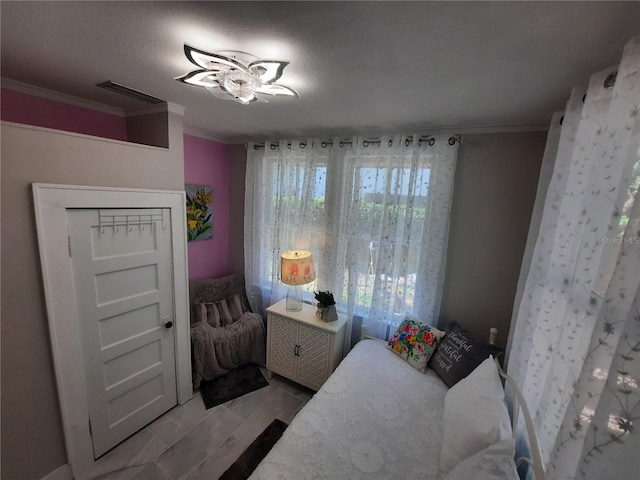 bedroom featuring ornamental molding and a textured ceiling