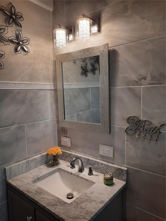 bathroom featuring vanity and tile walls