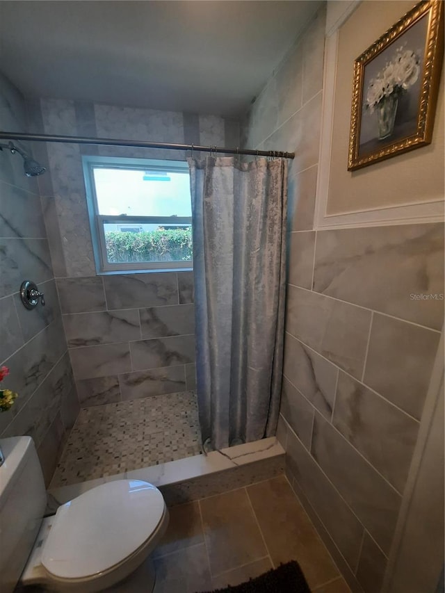 bathroom with a shower with curtain, toilet, and tile patterned flooring