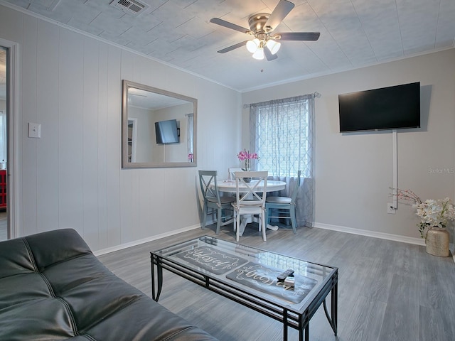 living room featuring crown molding, hardwood / wood-style floors, and ceiling fan