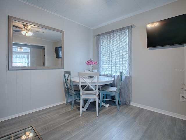dining space with ornamental molding, hardwood / wood-style floors, and ceiling fan