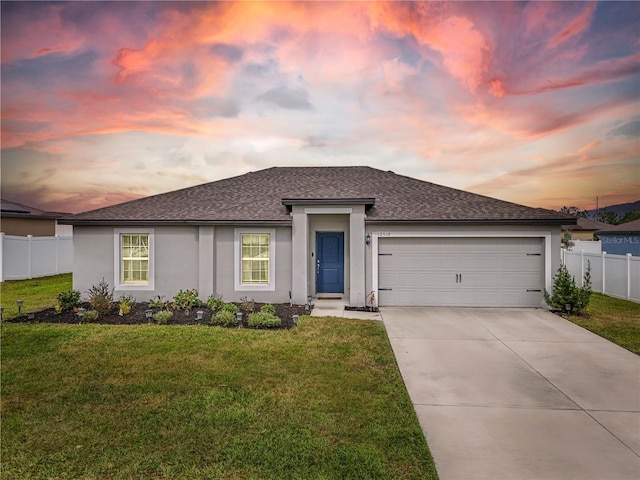 prairie-style house featuring a garage and a lawn