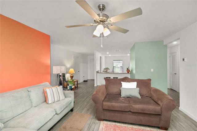 living room with ceiling fan and light wood-type flooring