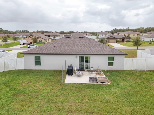 rear view of property with a yard and a patio area