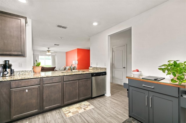 kitchen with sink, light stone counters, dark brown cabinets, stainless steel dishwasher, and light hardwood / wood-style floors