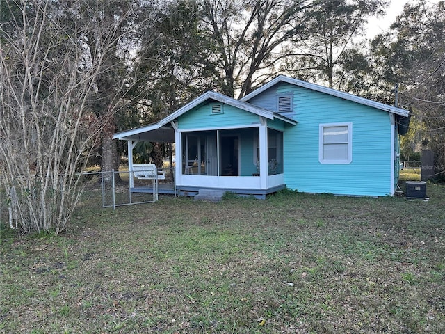 back of house featuring a yard and a sunroom