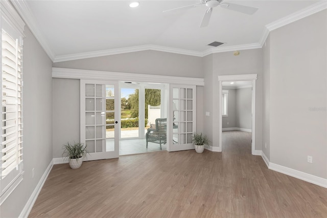 spare room with ornamental molding, lofted ceiling, french doors, and wood finished floors