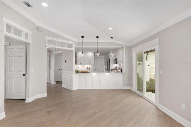 unfurnished living room featuring lofted ceiling, light wood-style flooring, visible vents, and ornamental molding