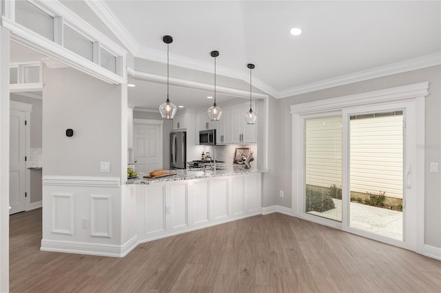 kitchen featuring crown molding, a peninsula, appliances with stainless steel finishes, and white cabinets