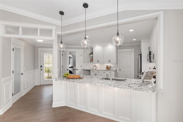 kitchen featuring white cabinets, light stone counters, stainless steel appliances, open shelves, and a sink