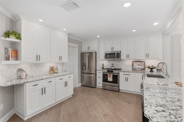 kitchen featuring open shelves, white cabinets, stainless steel appliances, and a sink