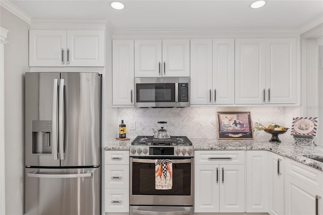 kitchen with appliances with stainless steel finishes, white cabinets, and tasteful backsplash