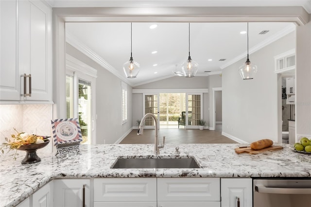 kitchen featuring ornamental molding, a sink, a wealth of natural light, and white cabinets