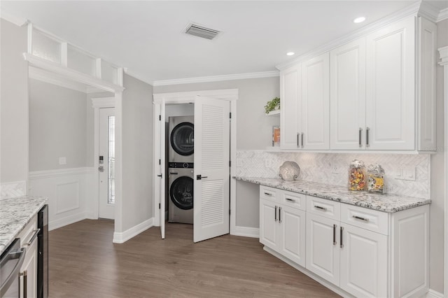 kitchen featuring open shelves, light stone counters, white cabinets, and stacked washer / drying machine