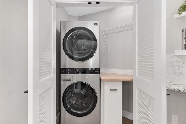 laundry room with stacked washer / drying machine and laundry area